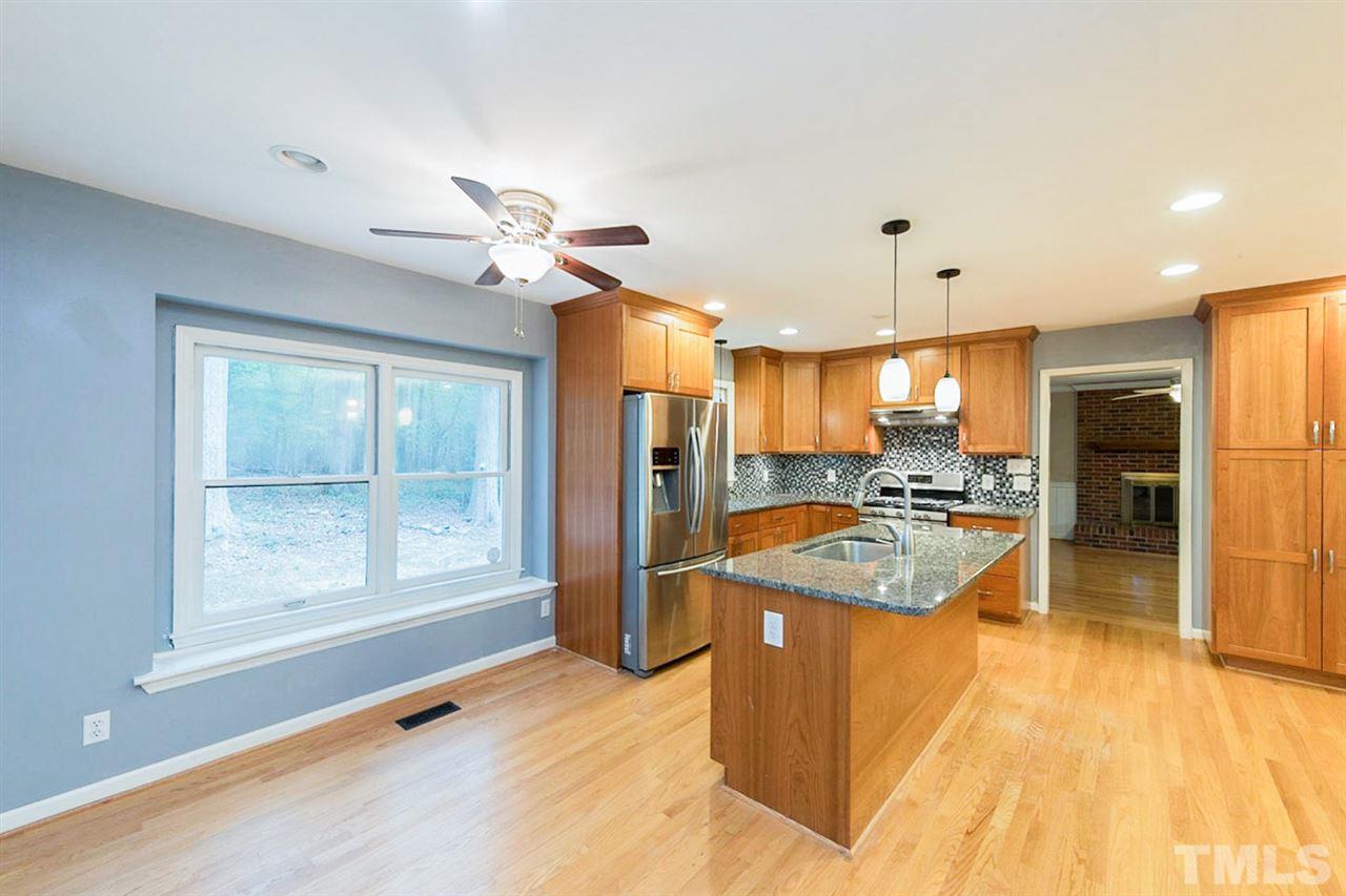 5208 Hallmark Road Durham, NC 27712 - Photo 10 of 25 a dining hall with stainless steel appliances granite countertop a refrigerator a sink a dining table and chairs with wooden floor