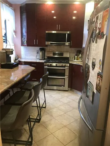 a kitchen with granite countertop a stove and a refrigerator