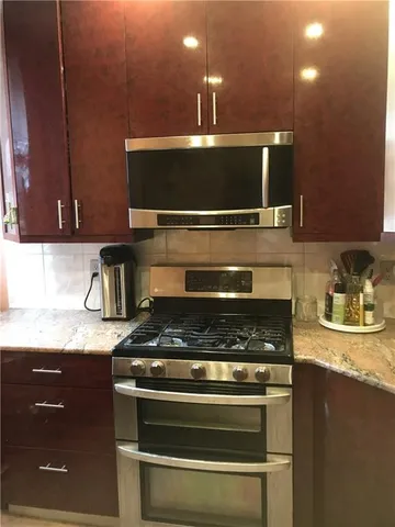 a kitchen with granite countertop a sink stainless steel appliances and cabinets