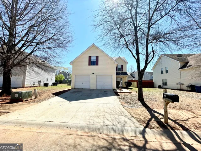 a view of a white house with a yard covered in snow