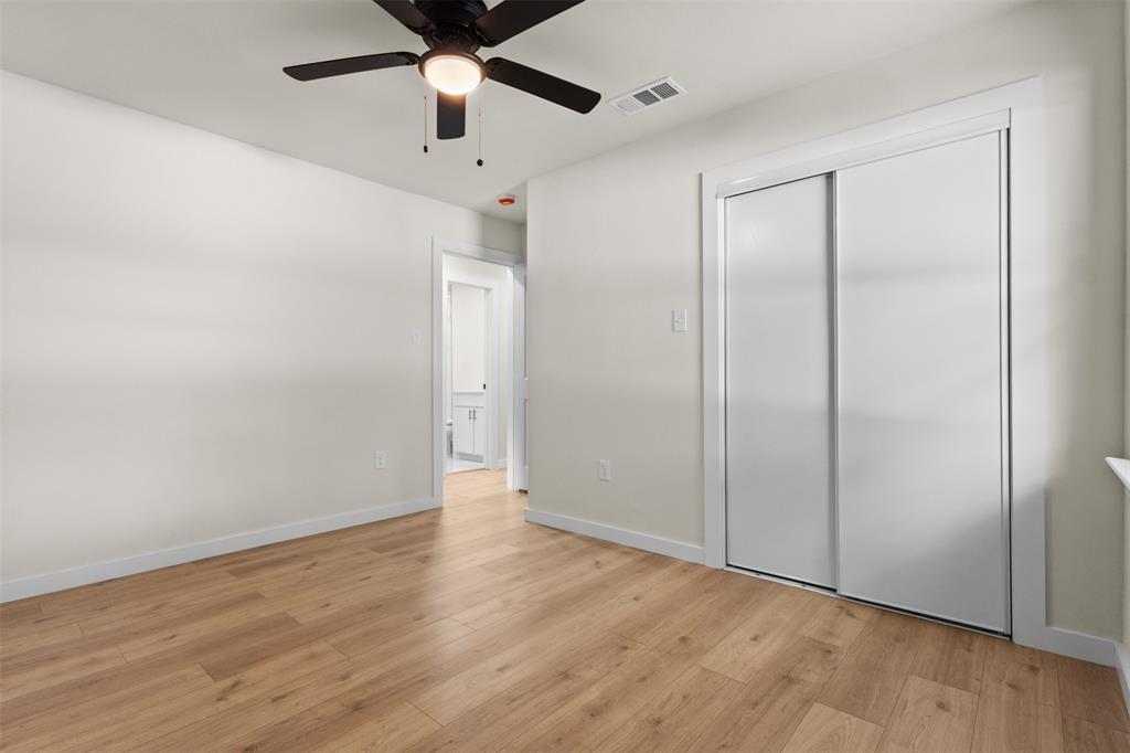 907 Pinson Road Forney, TX 75126 - Photo 21 of 35 Room featuring wood-finish flooring, a ceiling fan with integrated lighting, and a sliding door closet
