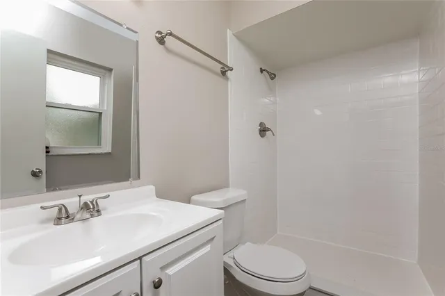 a bathroom with a sink toilet vanity and shower