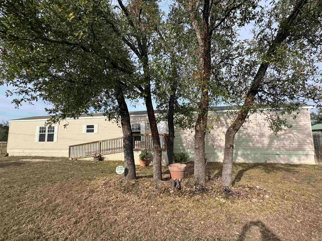 a backyard of a house with table and chairs