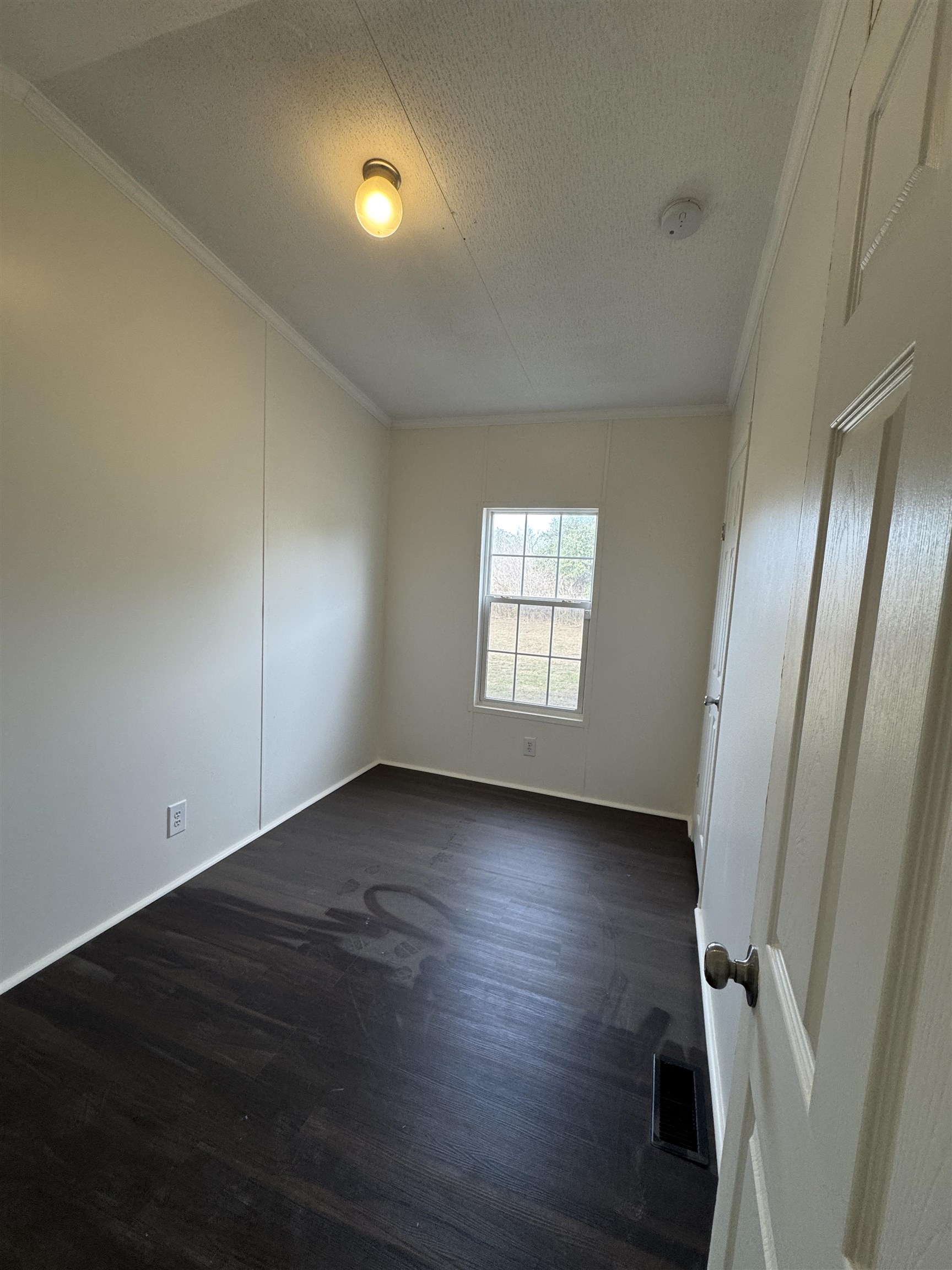 42 Reed Circle Bertram, TX 78605 - Photo 11 of 28 an empty room with wooden floor and windows