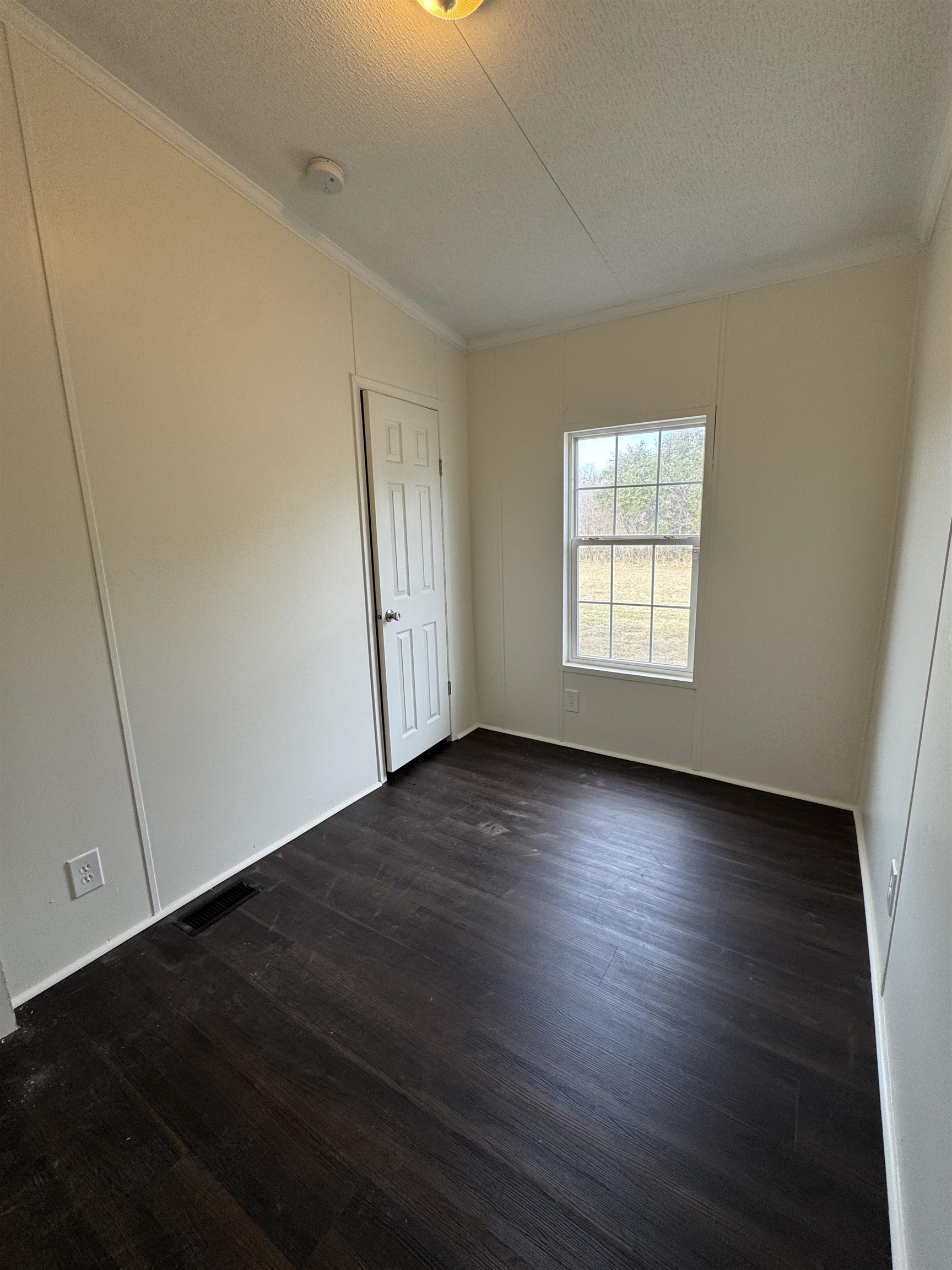 42 Reed Circle Bertram, TX 78605 - Photo 12 of 28 an empty room with wooden floor and windows