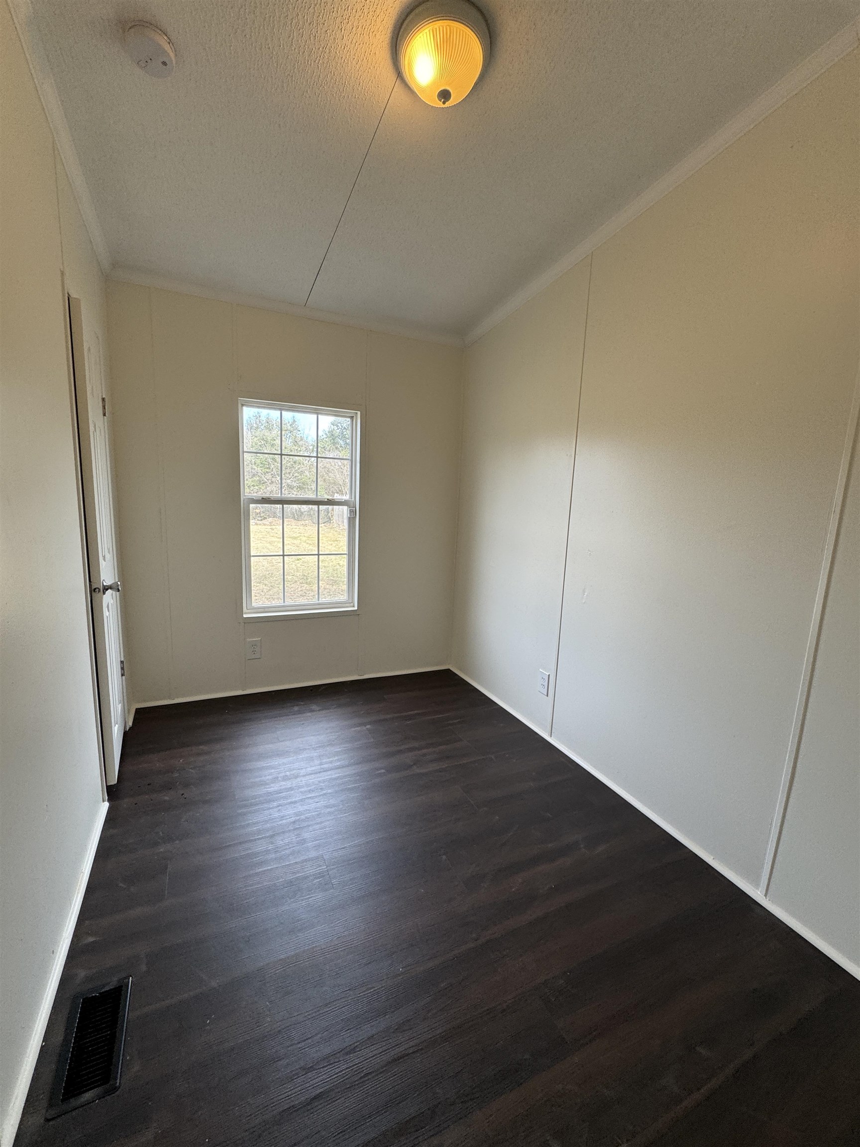 42 Reed Circle Bertram, TX 78605 - Photo 13 of 28 an empty room with wooden floor and windows