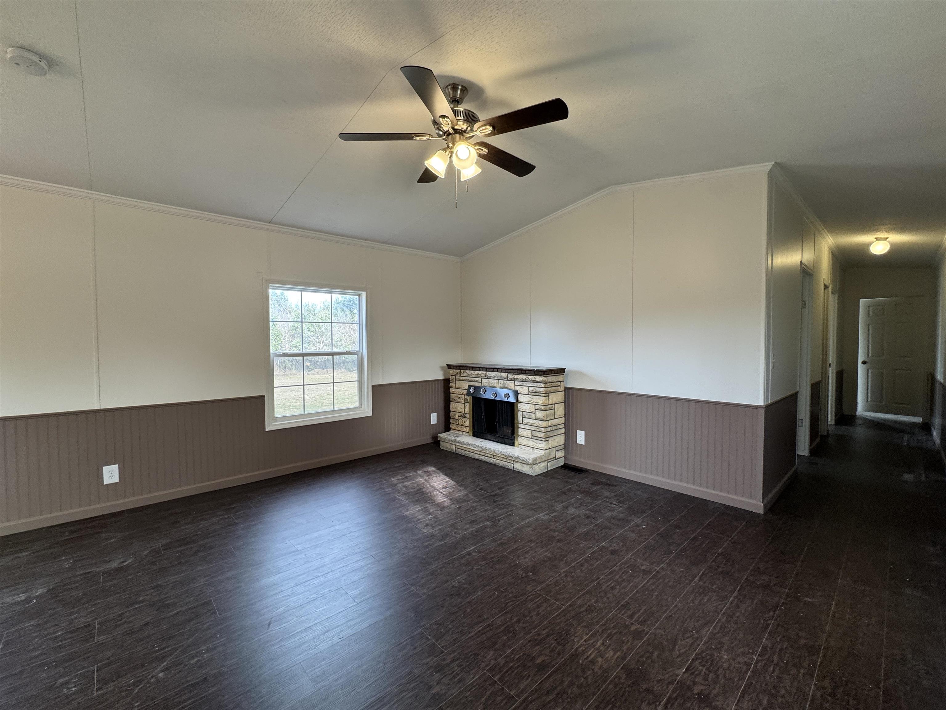 42 Reed Circle Bertram, TX 78605 - Photo 2 of 28 a view of an empty room with wooden floor and a ceiling fan
