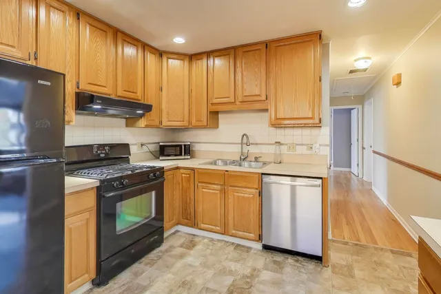 a kitchen with stainless steel appliances granite countertop a stove a sink and a refrigerator
