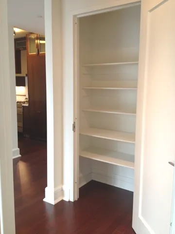 a view of walk in closet with empty racks