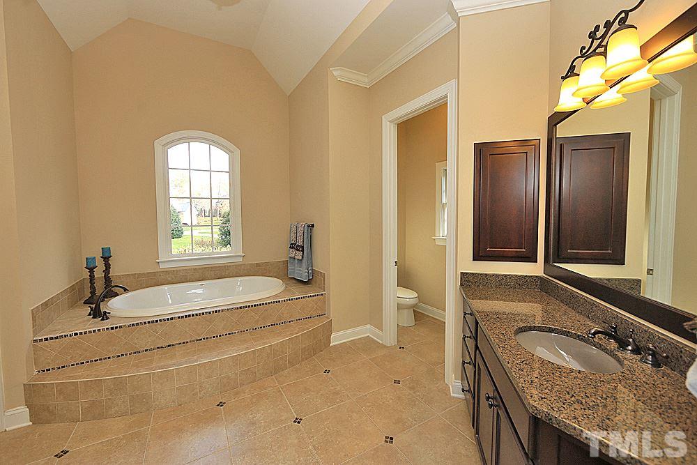 103 Duckhead Point Cary, NC 27518 - Photo 11 of 25 a spacious bathroom with a granite countertop tub sink and mirror