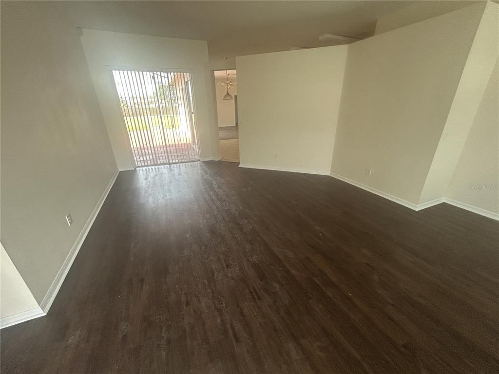 1332 Hatcher Loop Drive Brandon, FL 33511 - Photo 4 of 35 wooden floor in an empty room with a window