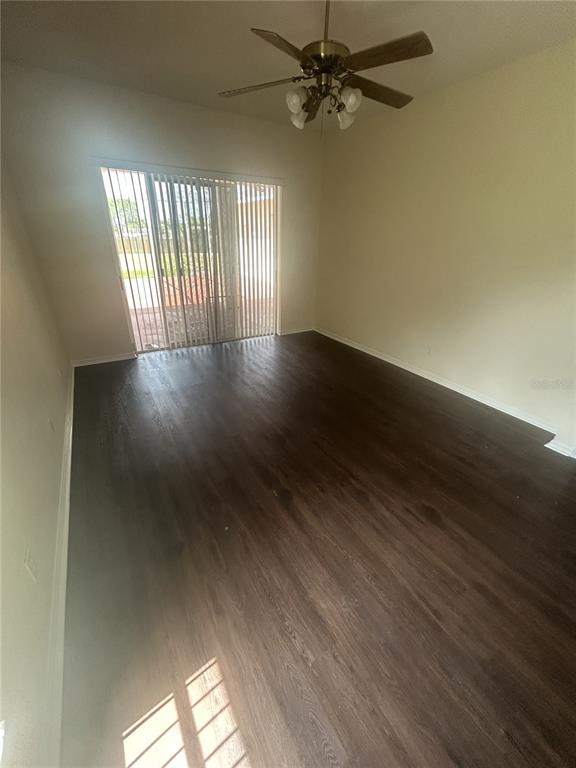 1332 Hatcher Loop Drive Brandon, FL 33511 - Photo 7 of 35 an empty room with wooden floor fan and windows
