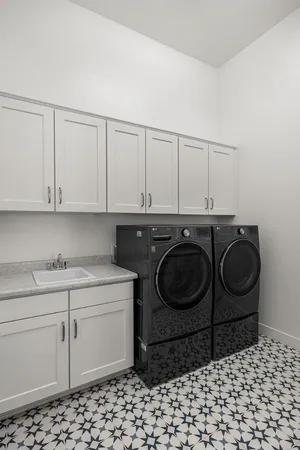 a utility room with sink dryer and washer