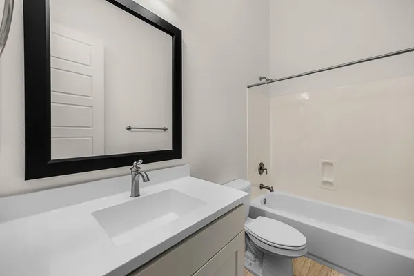a bathroom with a sink toilet a mirror and shower