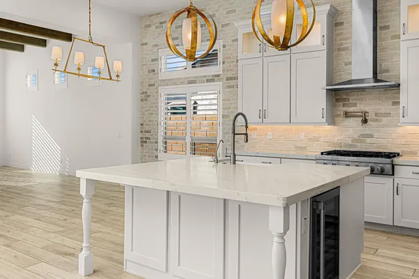 a kitchen with stainless steel appliances granite countertop a sink a stove and a wooden floor