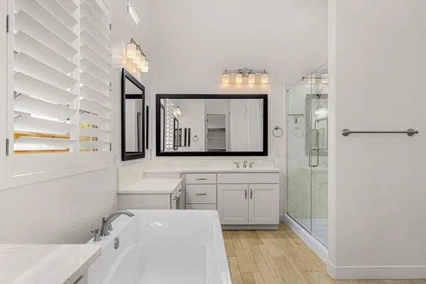 a bathroom with a bathtub sink and mirror