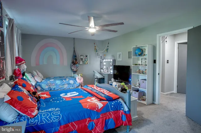a bedroom with a bed and a flat tv screen on dresser