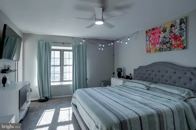 a bedroom with a balcony a bed and a flat screen tv