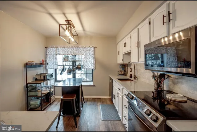 a kitchen with stainless steel appliances granite countertop a stove and cabinets