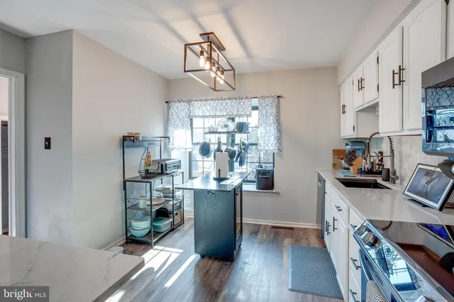 a kitchen with stainless steel appliances a white cabinets and wooden floor