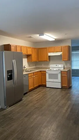 a kitchen with stainless steel appliances granite countertop a refrigerator a stove and a sink