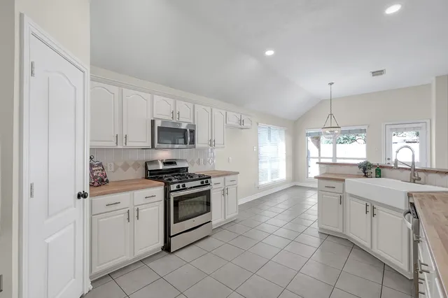 a kitchen with white cabinets stainless steel appliances and sink