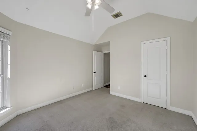 an empty room with a chandelier fan