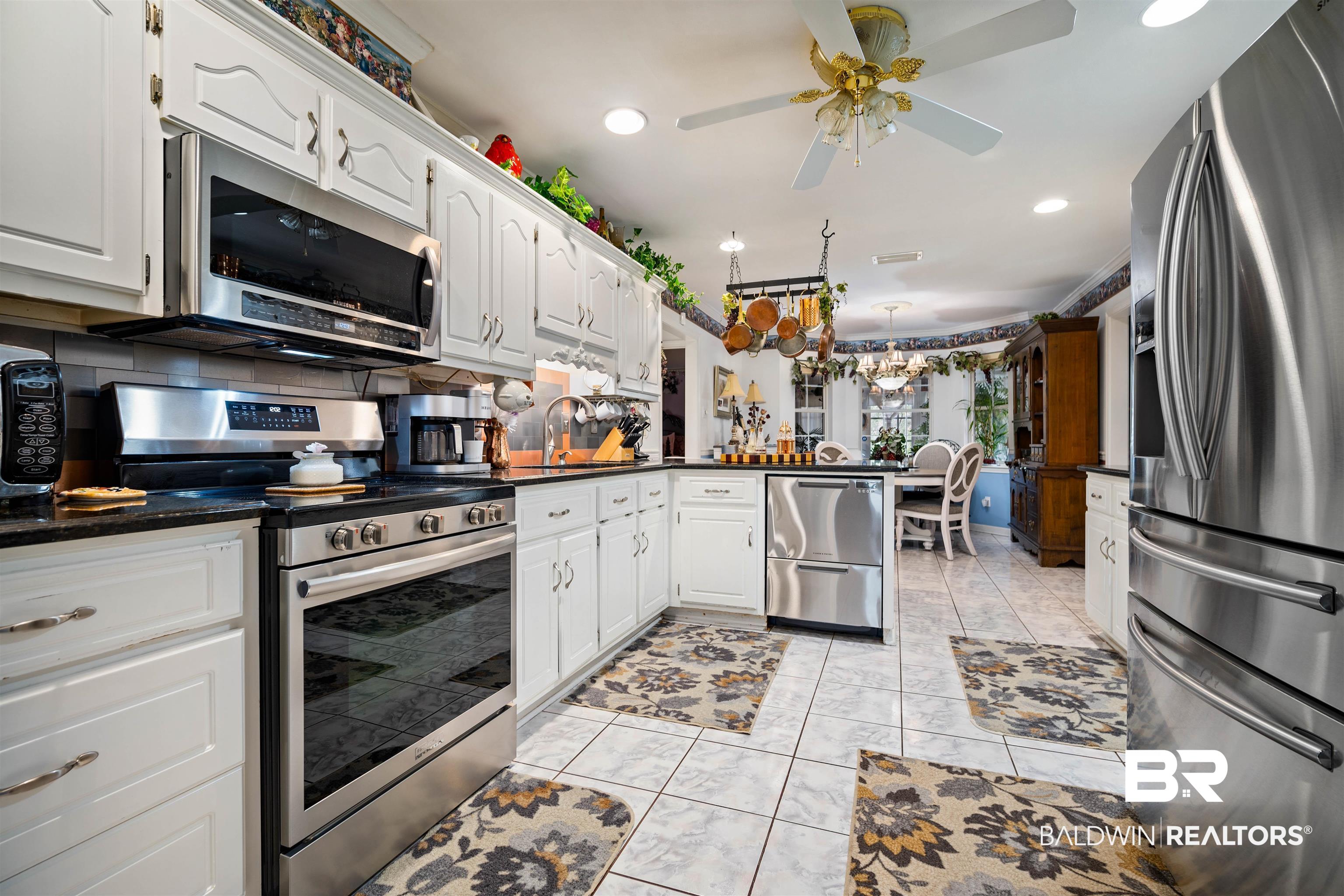 1744 Aden Road Mobile, AL 36695 - Photo 12 of 35 Kitchen with white cabinets, stainless steel appliances, decorative backsplash, and kitchen peninsula