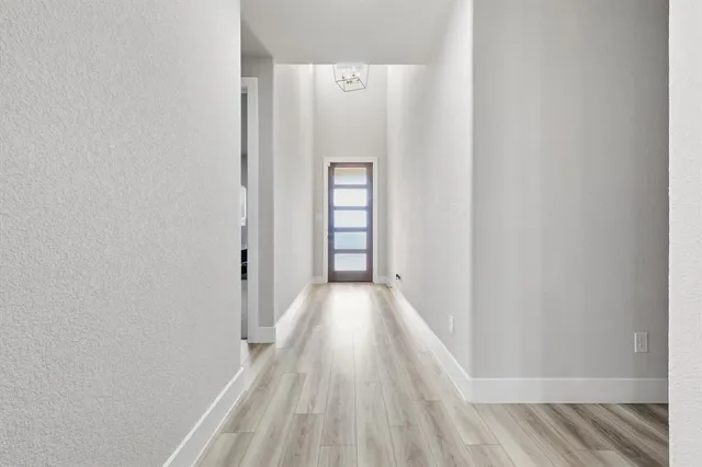 a kitchen with a stove a sink dishwasher a dining table and chairs with wooden floor