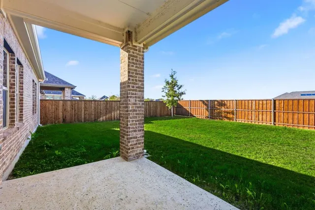 a view of a backyard with wooden fence