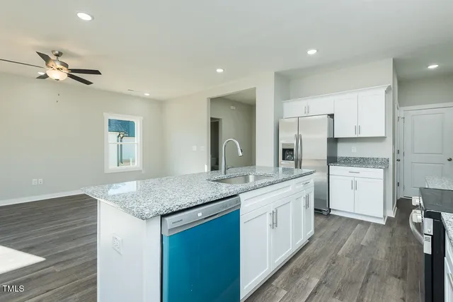 a kitchen with granite countertop stainless steel appliances a sink stove top oven and cabinets