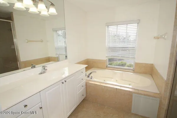 a bathroom with a tub sink and mirror