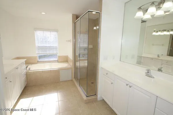 a bathroom with a tub sink and mirror