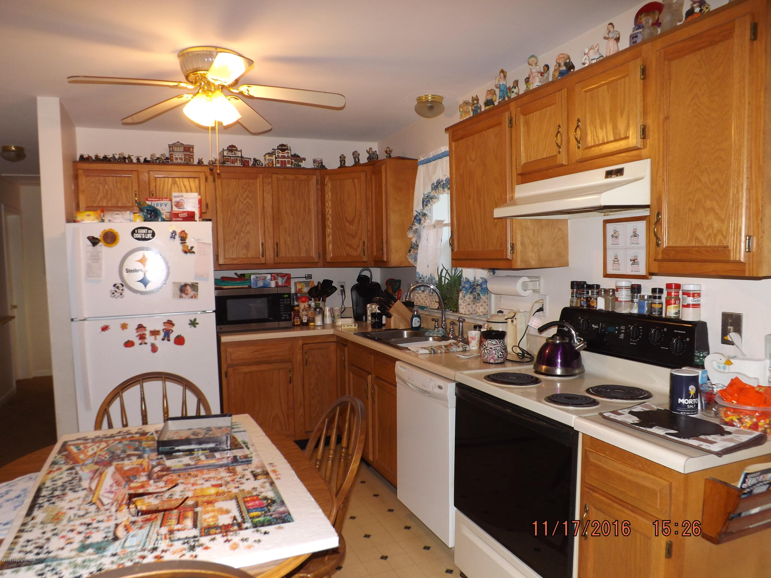 3259 Spruce Cabin Road Cresco, PA 18326 - Photo 8 of 14 a kitchen with stainless steel appliances granite countertop a stove top oven a sink a dining table and chairs with wooden floor