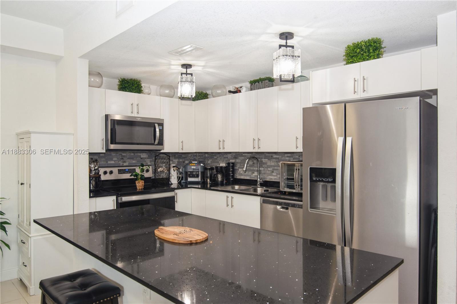 14366 Southwest 258th Lane Homestead, FL 33032 - Photo 6 of 24 a kitchen with stainless steel appliances granite countertop a sink a stove and a refrigerator