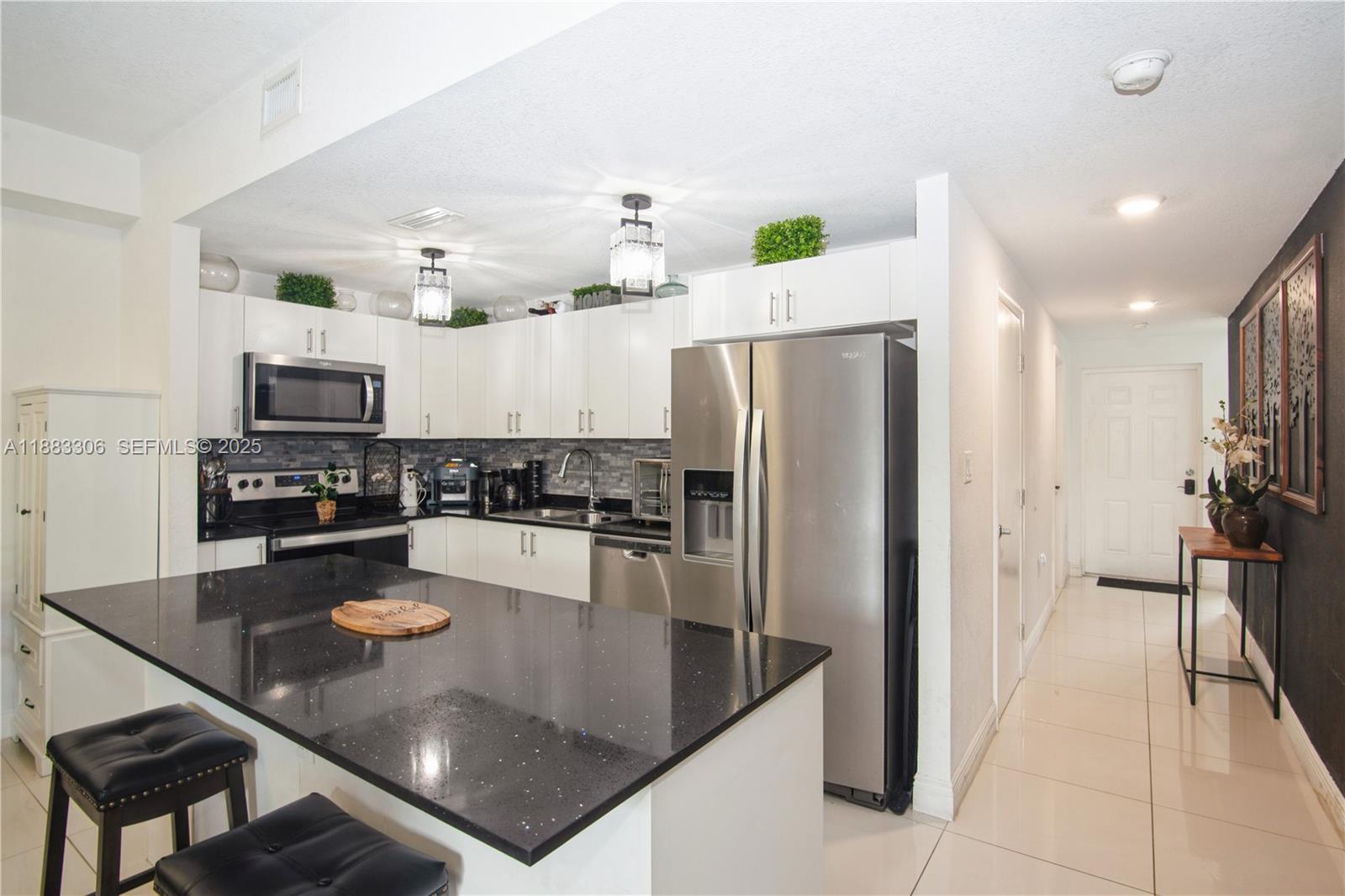 14366 Southwest 258th Lane Homestead, FL 33032 - Photo 10 of 24 a kitchen with a refrigerator a stove a microwave and cabinets