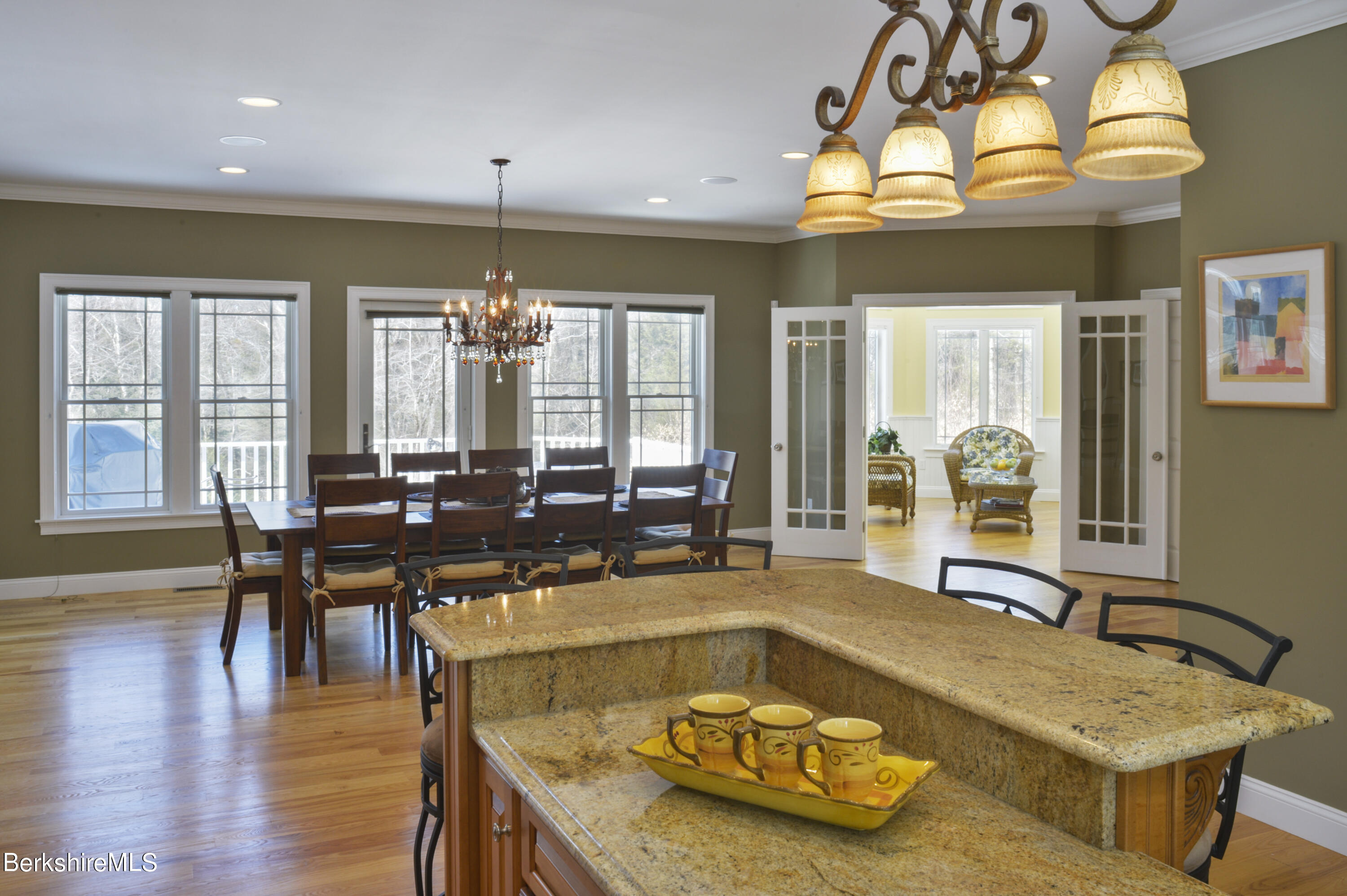249 Woodmere Road Becket, MA 01223 - Photo 6 of 23 a living room with dining table and a chandelier