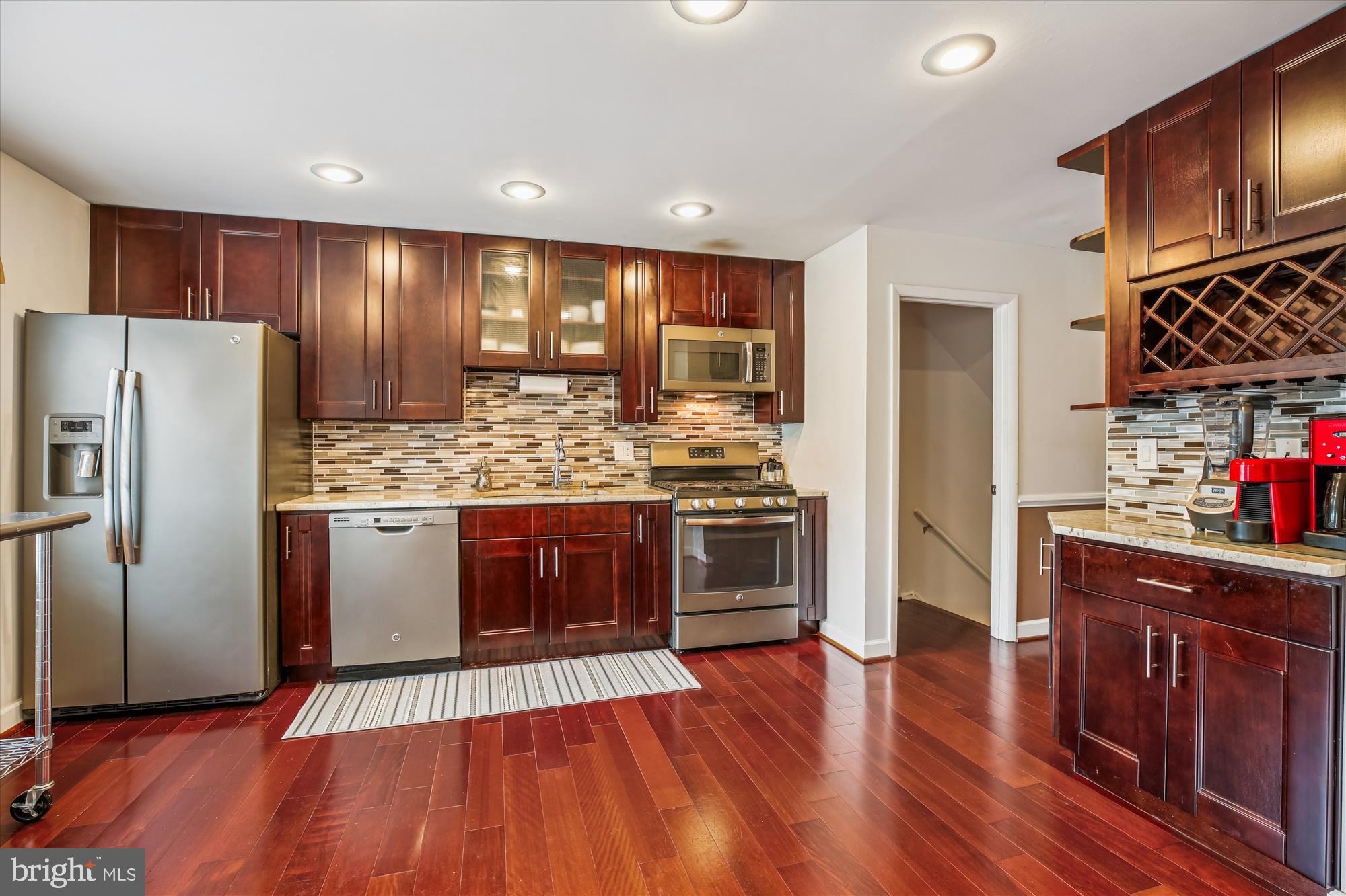 2702 Atlanta Drive, Unit 72702 Silver Spring, MD 20906 - Photo 15 of 55 a kitchen with stainless steel appliances kitchen island granite countertop wooden floors and cabinets