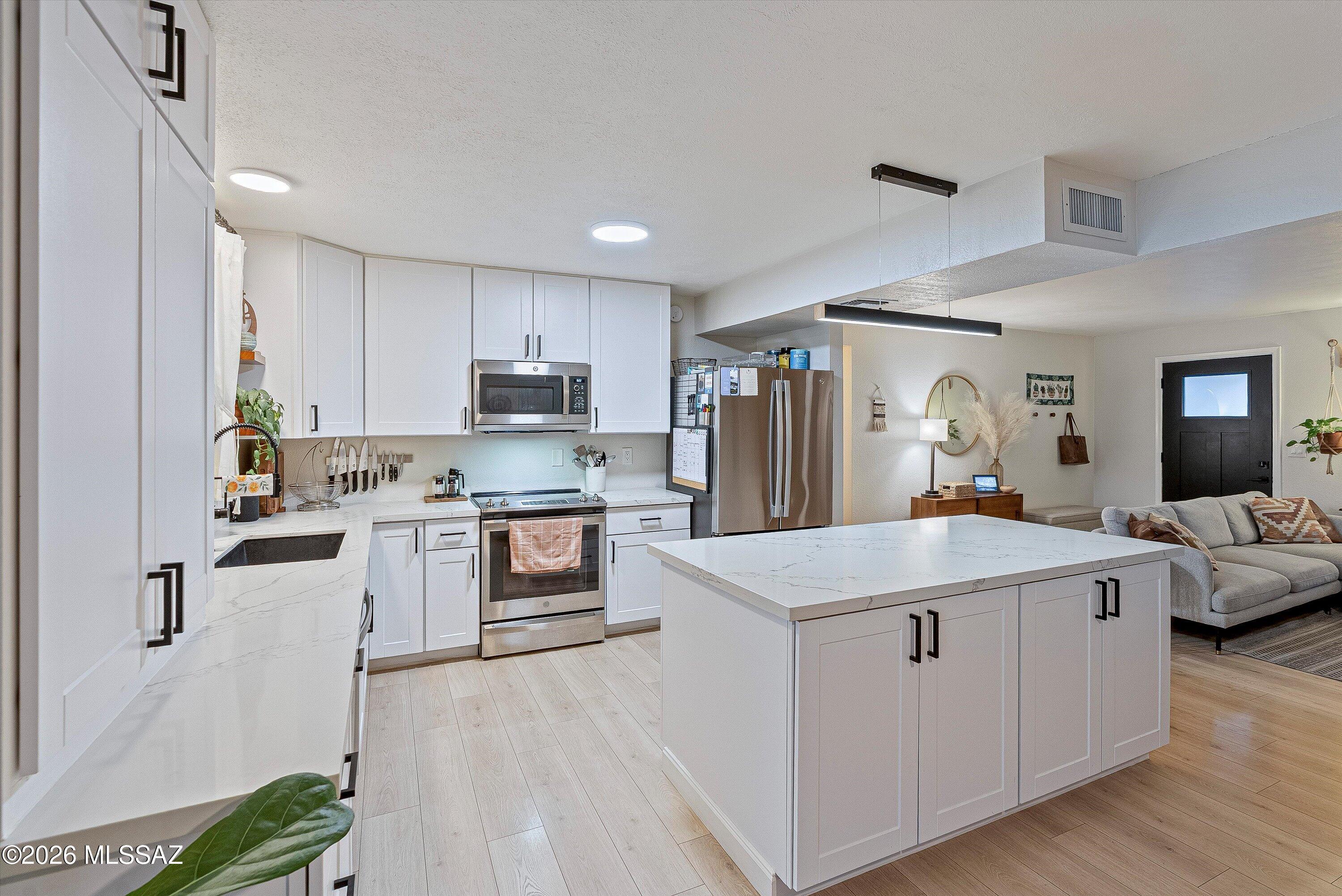 3949 West Mars Street Tucson, AZ 85741 - Photo 25 of 27 a kitchen with a sink stove and refrigerator