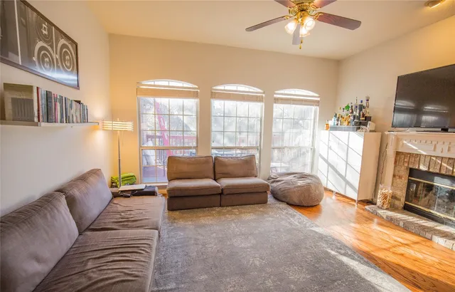 a living room with furniture a flat screen tv and a floor to ceiling window