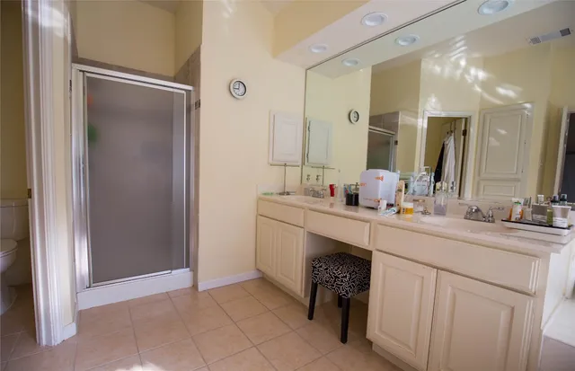 a spacious bathroom with a double vanity sink a mirror and a