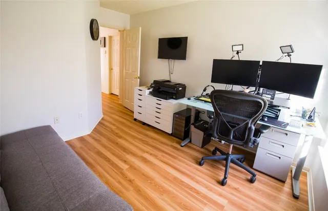 a bedroom with a bed a dresser and a flat screen tv