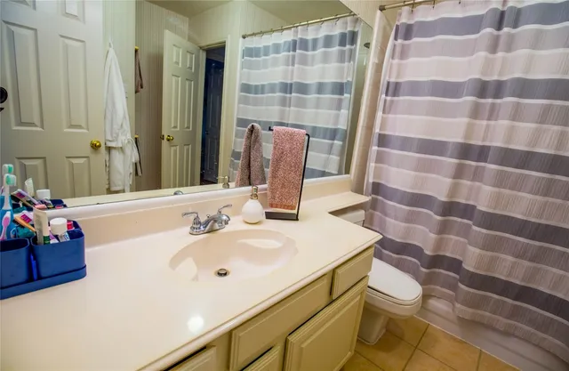 a bathroom with a sink a toilet a mirror and shower