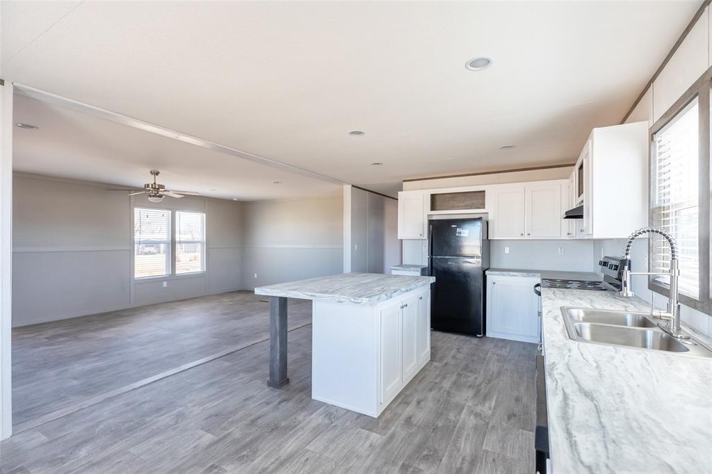 420 Haynes Street Merkel, TX 79536 - Photo 11 of 27 a kitchen with stainless steel appliances granite countertop a stove top oven a sink dishwasher and a refrigerator with wooden floor