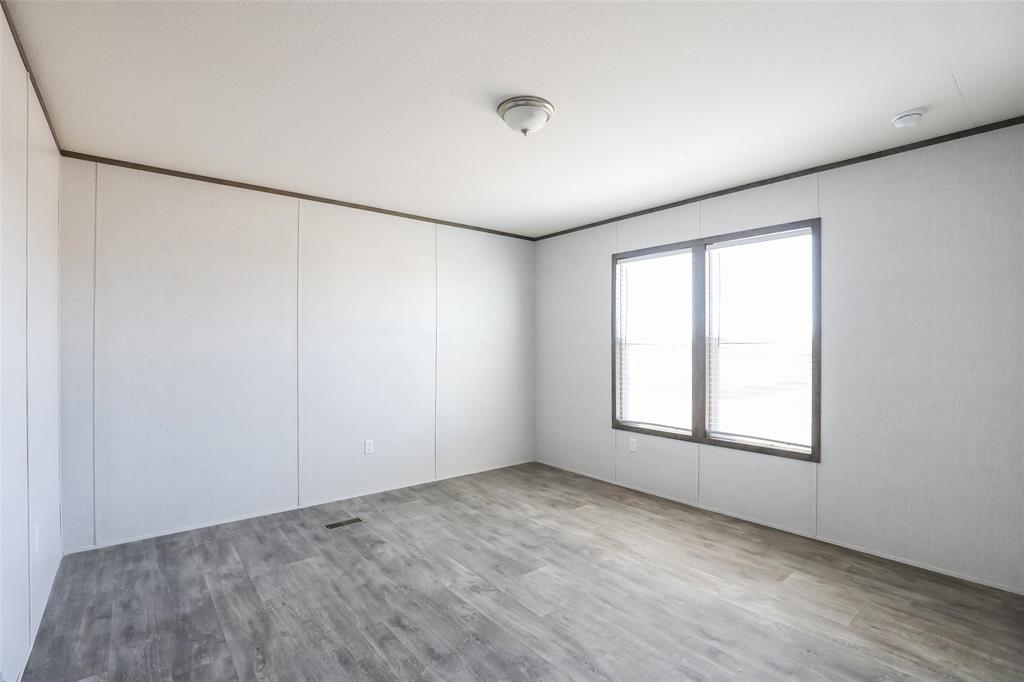 420 Haynes Street Merkel, TX 79536 - Photo 13 of 27 an empty room with wooden floor and windows