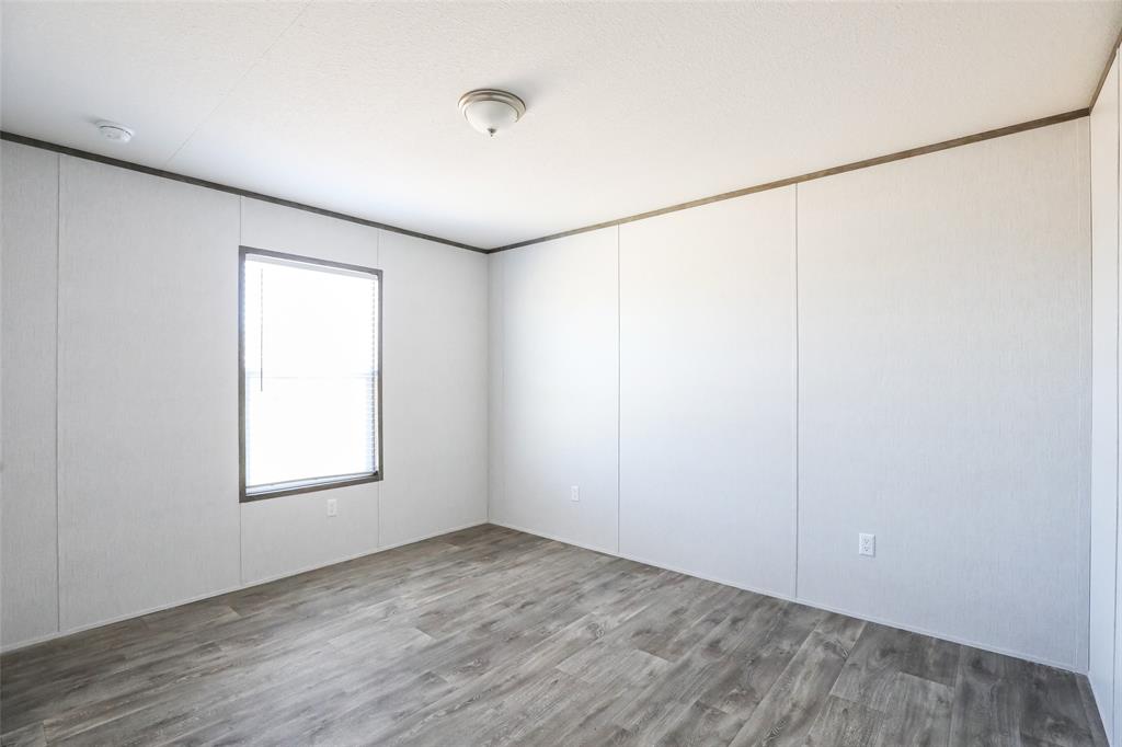 420 Haynes Street Merkel, TX 79536 - Photo 22 of 27 an empty room with wooden floor and windows