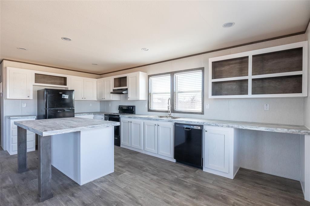 420 Haynes Street Merkel, TX 79536 - Photo 8 of 27 a kitchen with cabinets wooden floor and stainless steel appliances