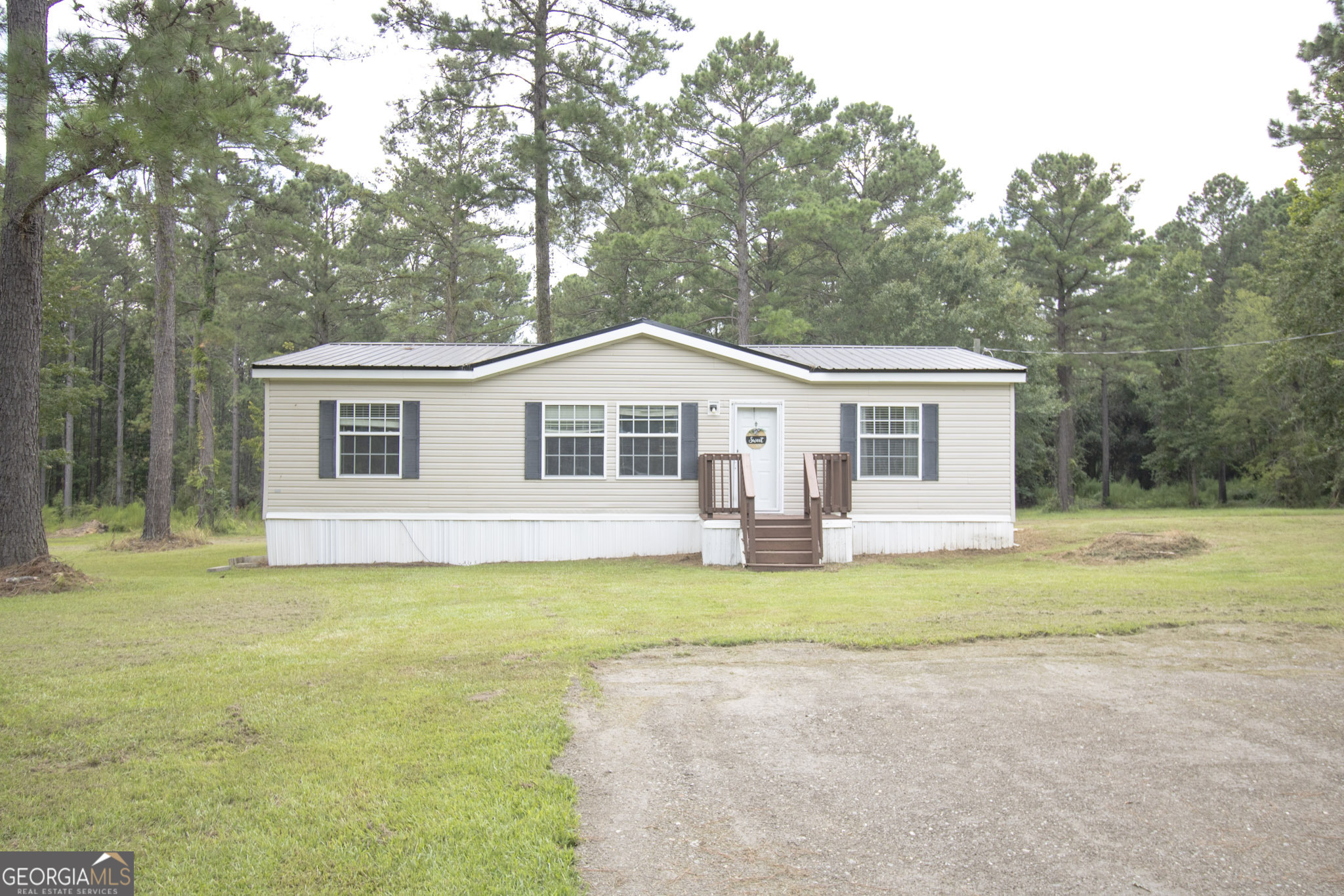 1776 Zettwell Road Statesboro, GA 30461 - Photo 2 of 20 a view of a house with a yard and large trees