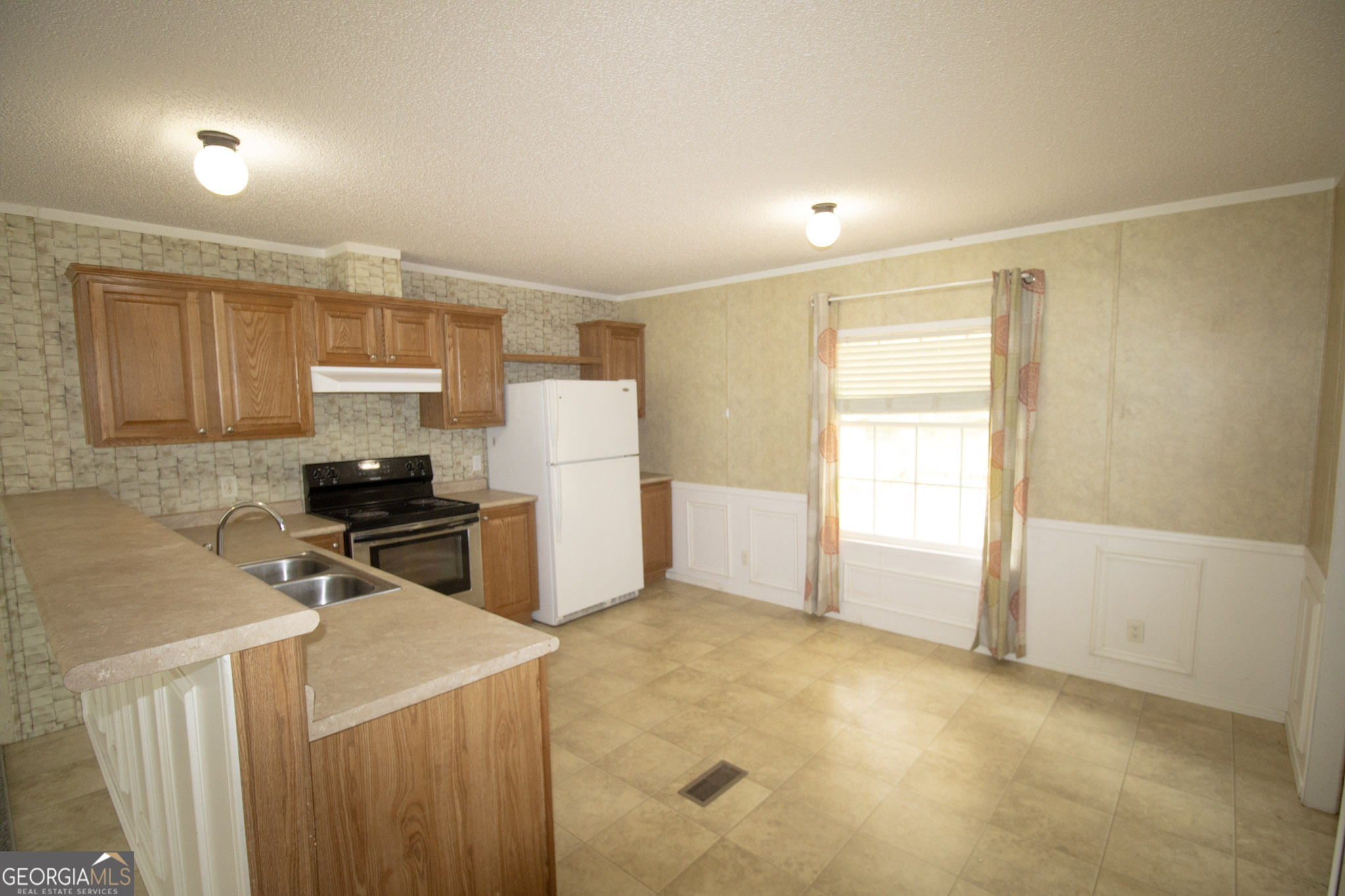 1776 Zettwell Road Statesboro, GA 30461 - Photo 5 of 20 a kitchen with a refrigerator and a stove top oven