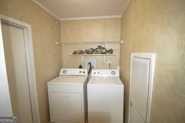 a view of washer and dryer with kitchen in the background